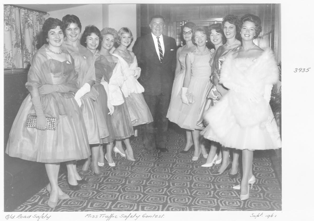 Miss Traffic Safety Quest 1961 contestants in evening dress, with judge - Brisbane, September 1961