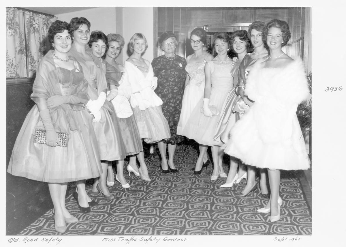 Miss Traffic Safety Quest 1961 contestants in evening dress, with judge - Brisbane, September 1961