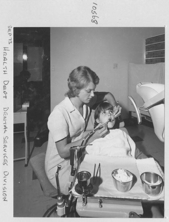 Dentist from the Health Department Dental Services Division examining child - Brisbane, September 1973