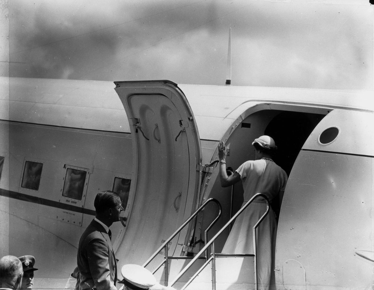 Queen Elizabeth II waves to well-wishers as she boards an aeroplane during her visit in March 1954, Brisbane