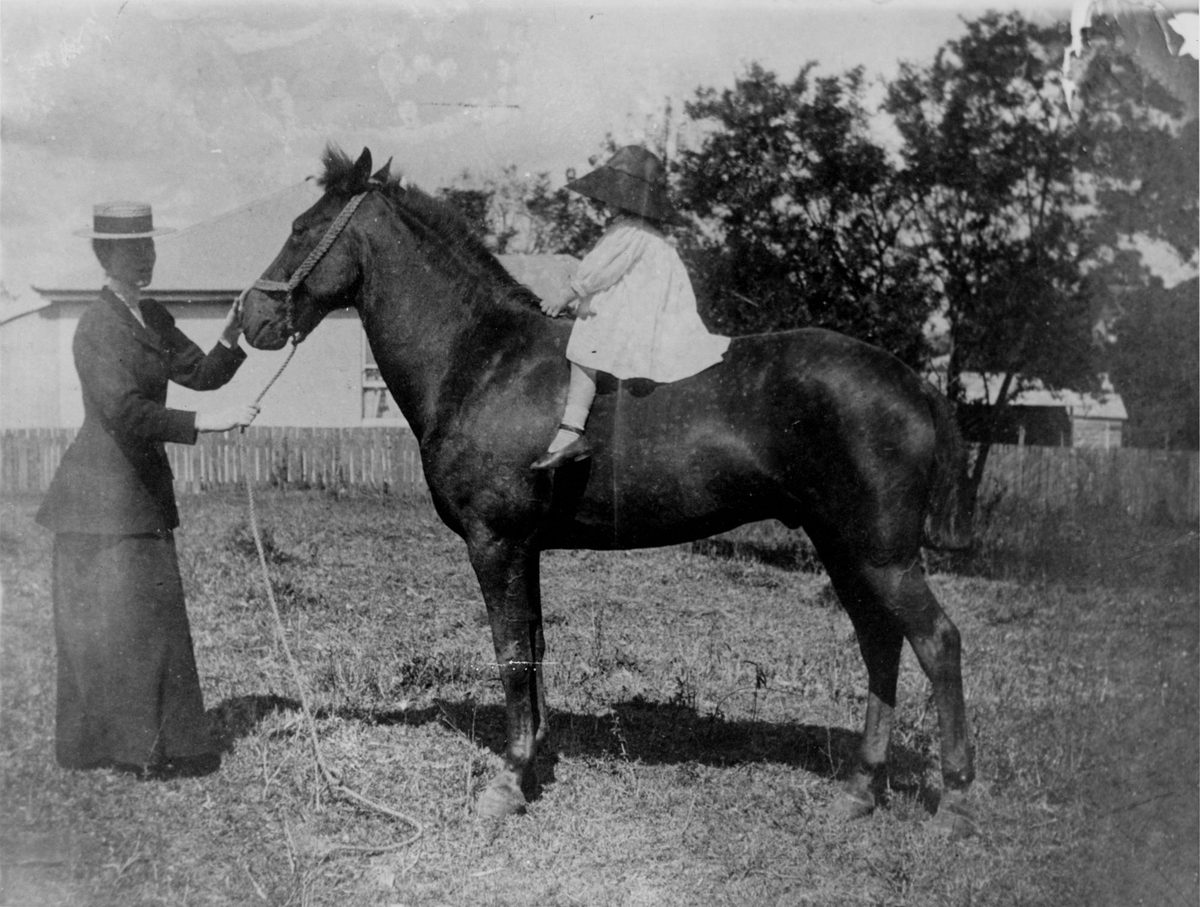 Mrs. Elsie Stuart supervising her daughter, Wanda, on 'Bubbles' the horse, 1899, Indooroopilly