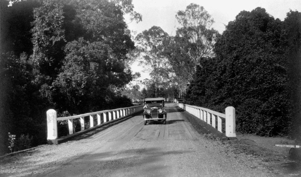 Austin motor vehicle crossing a bridge at Burpengary, 1934