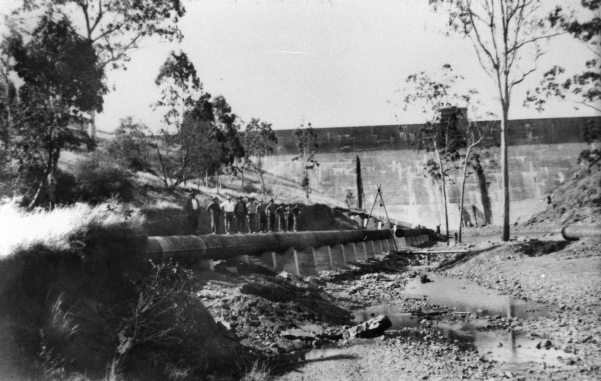 Workmen on the pipework beside Lake Manchester Dam wall, 1931, Mount Crosby