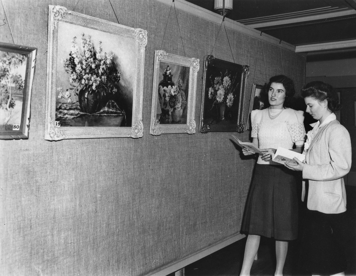 Young women admiring an exhibition of paintings at Finneys' Art Gallery, June 1948, Brisbane