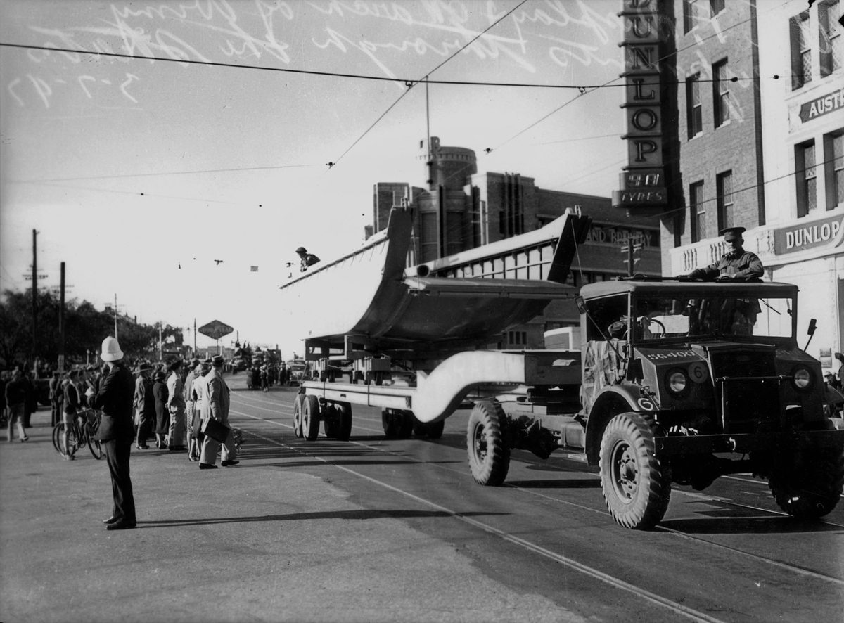Parade of military equipment, including a truck carrying a landing craft, Brisbane, July 1942