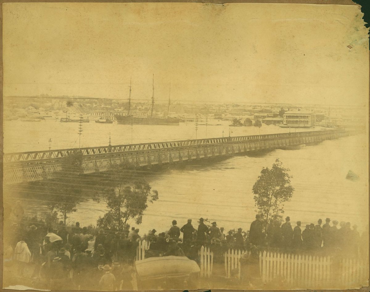 Spectators watch as floodwaters threaten to wash away Victoria Bridge, Brisbane, 1893, Brisbane City