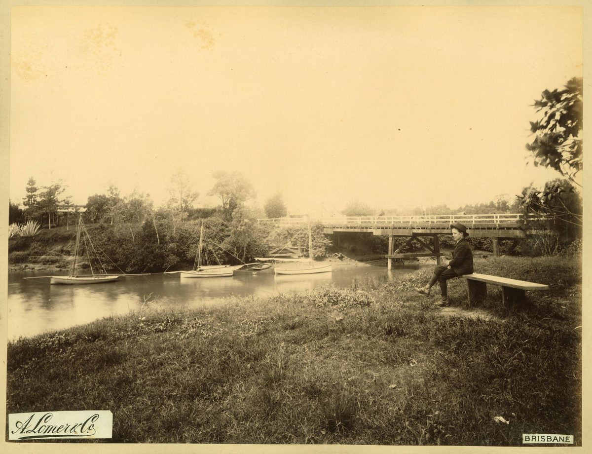 Young man sitting on a bench watching the boats in Norman Creek, Brisbane, 1889