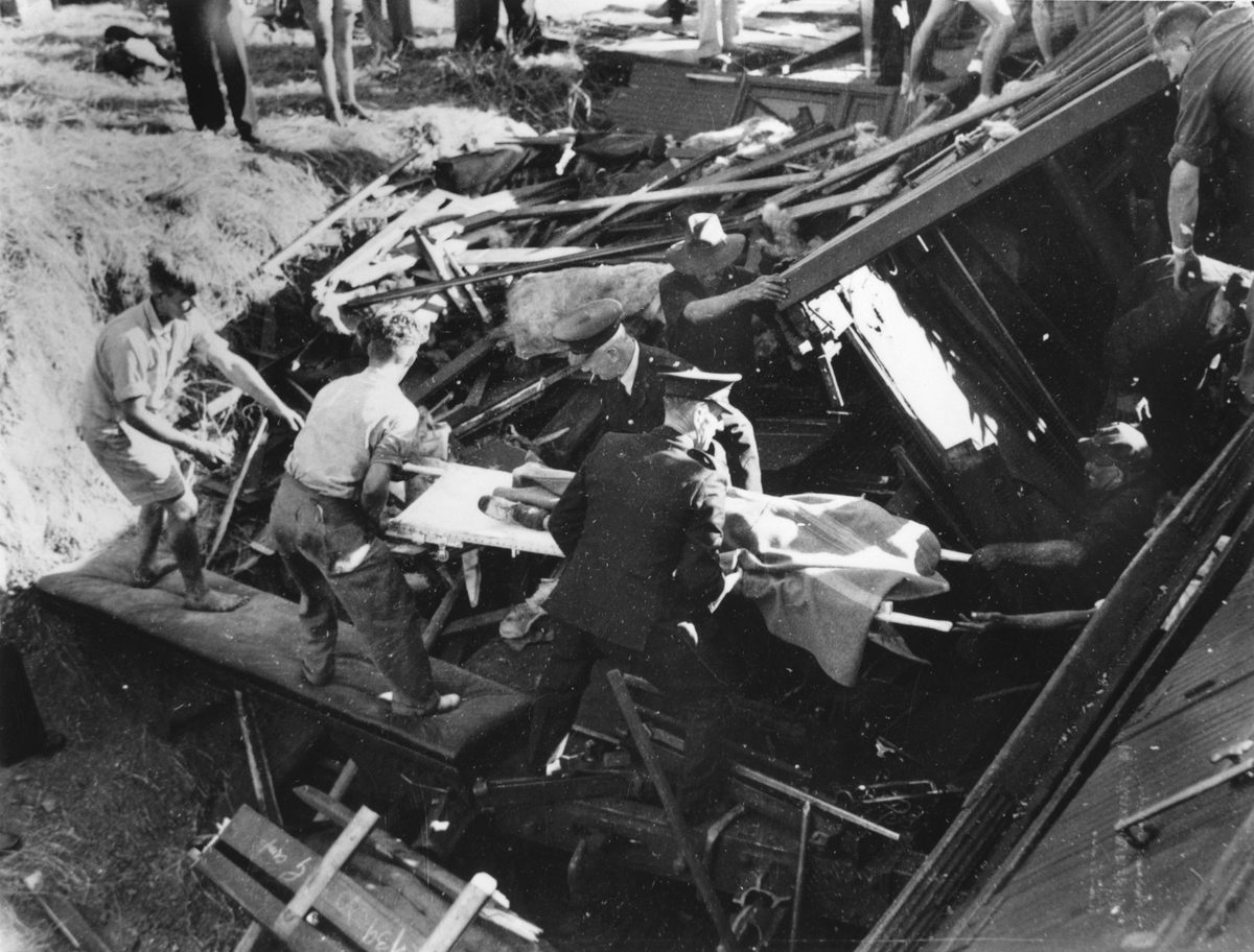 Body being carried by stretcher from the train wreckage by rescue workers at Camp Mountain, 1947