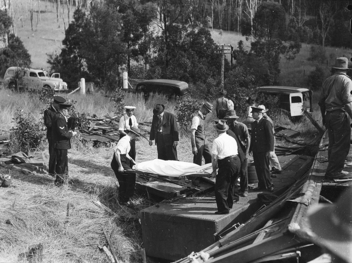 Rescue workers remove a body from a railway carriage at Camp Mountain, 1947