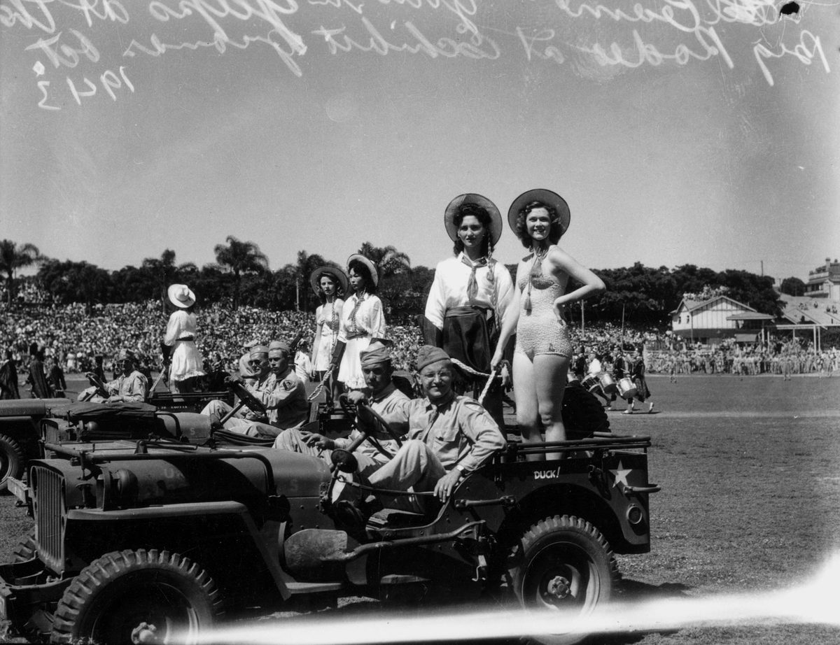 Showgirls riding in the back of United States Army jeeps as part of a parade for a Rodeo, Brisbane, 1943