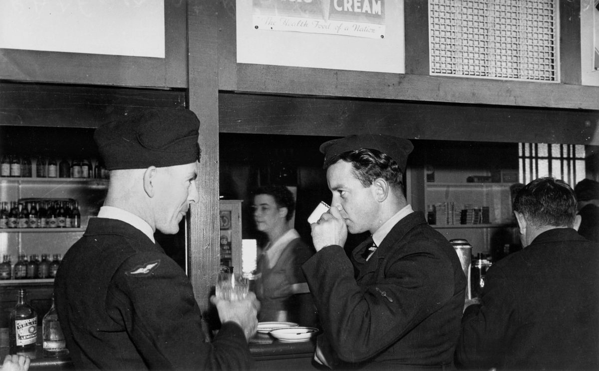 RAAF personnel having a last drink at the kiosk before leaving by train for camp in the south, Brisbane, June 1940