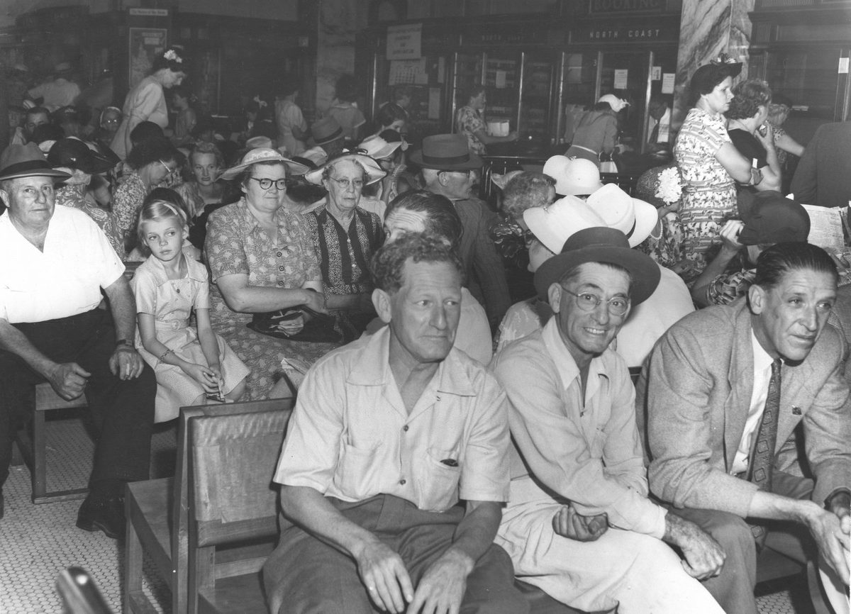 Crowd in the booking area inside the Government Tourist Bureau, Brisbane, 1954