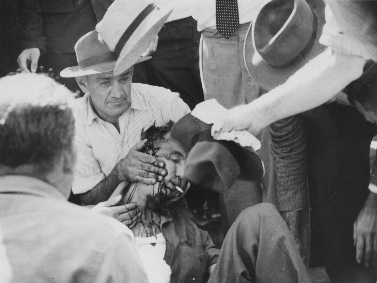Fellow Union members assisting Jack Grayson, injured during the Railway Workers' Strike of 1948, Brisbane City