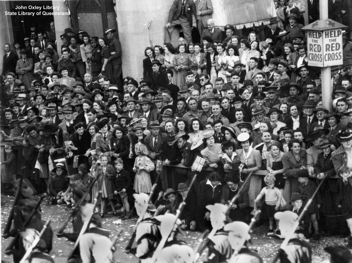 Crowd on Queen Street, Brisbane, watches the Seventh Division troops pass by the General Post Office, Brisbane City (1944)
