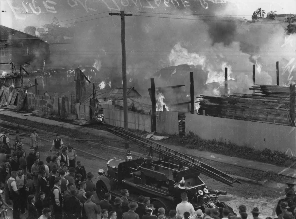 Crowds gather to observe a fire in Montague Road, South Brisbane, 1940