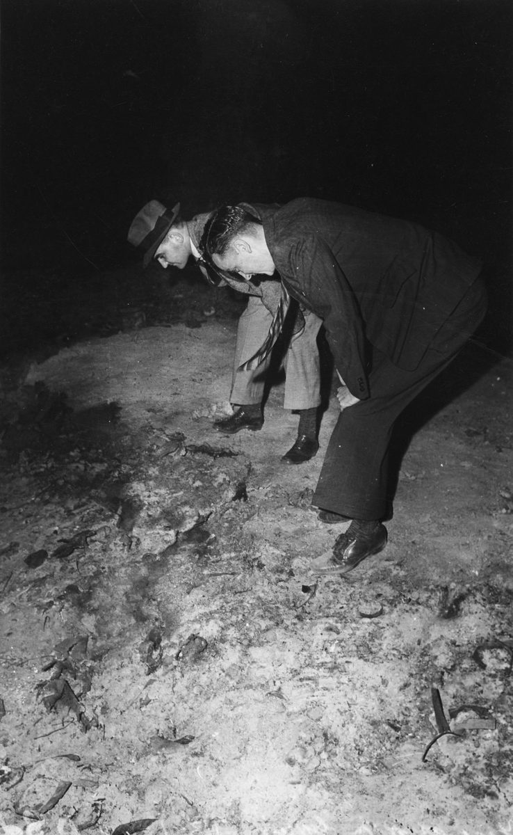 Two men investigate the site of the fire which destroyed the business premises of R.M. Gow & Co. Pty. Ltd. in Turbot Street, Brisbane, 1942, Brisbane City