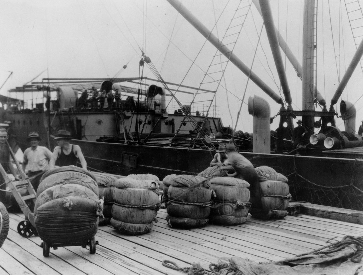 Goods wrapped in hessian bales being unloaded at a Brisbane wharf in 1930