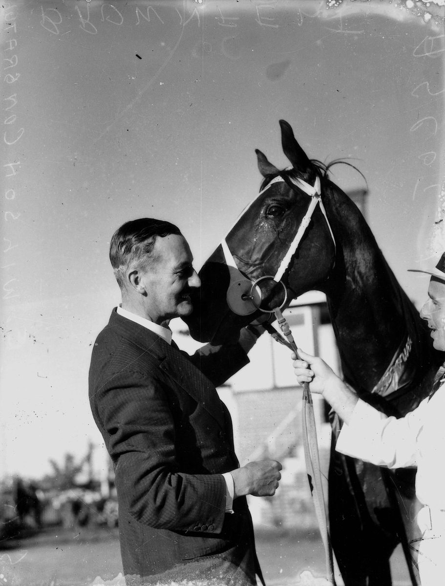Sir Leslie Wilson congratulates a horse and trainer at the Ascot races, Brisbane, May 1937