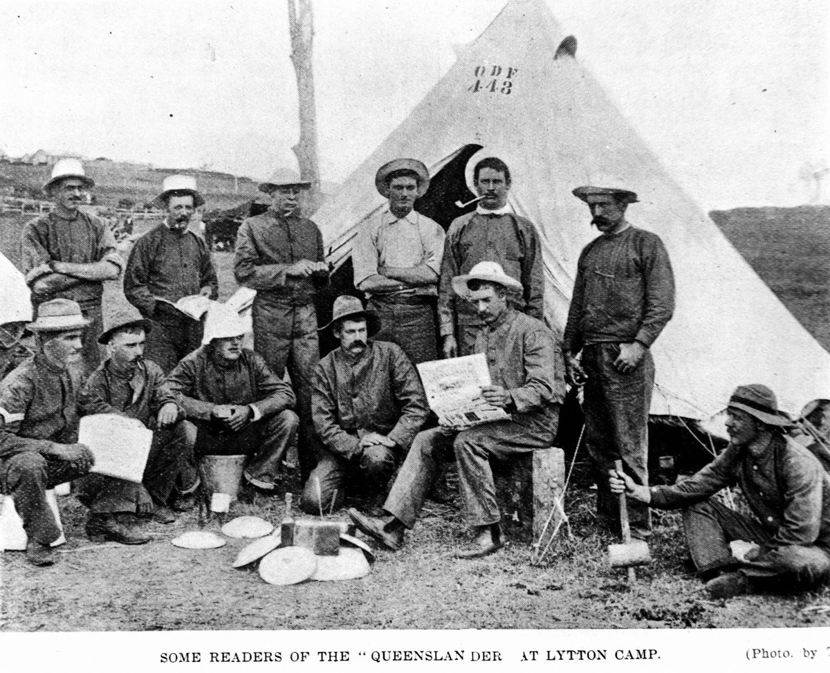 Men reading The Queenslander newspaper at the Fort Lytton camp, 1900