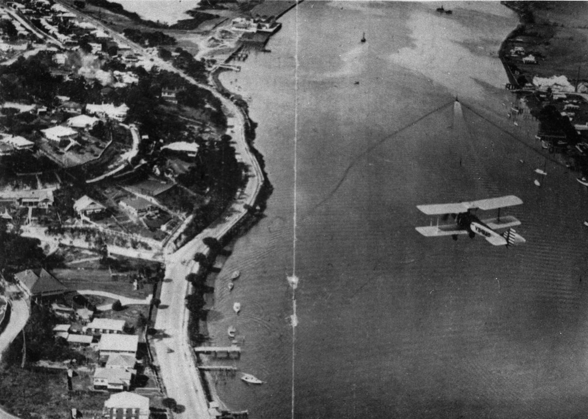 Light plane flying over the Hamilton Reach of the Brisbane River, 1929