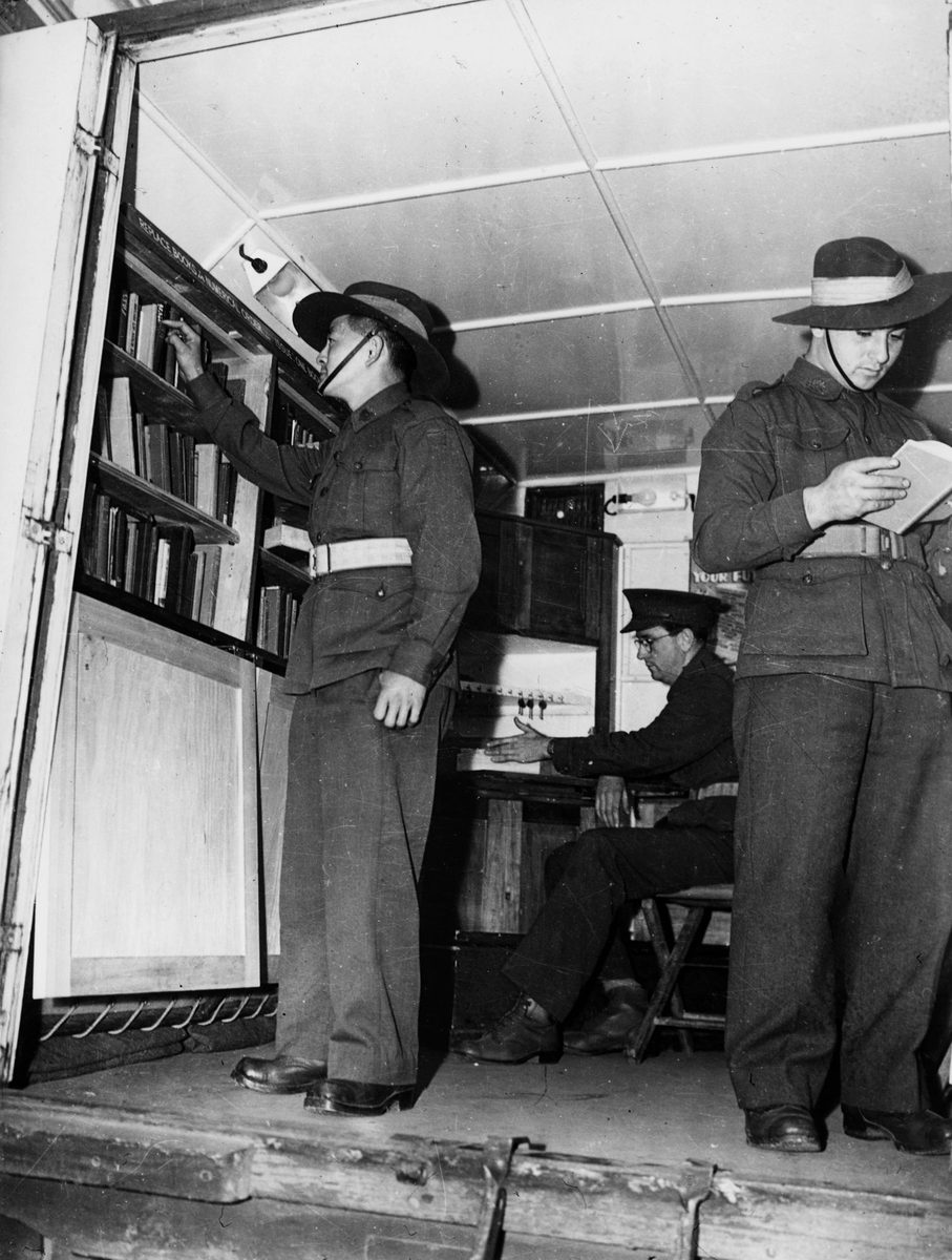 Soldiers browsing the shelves of the Army Education Service's Mobile Library, Brisbane, 1944
