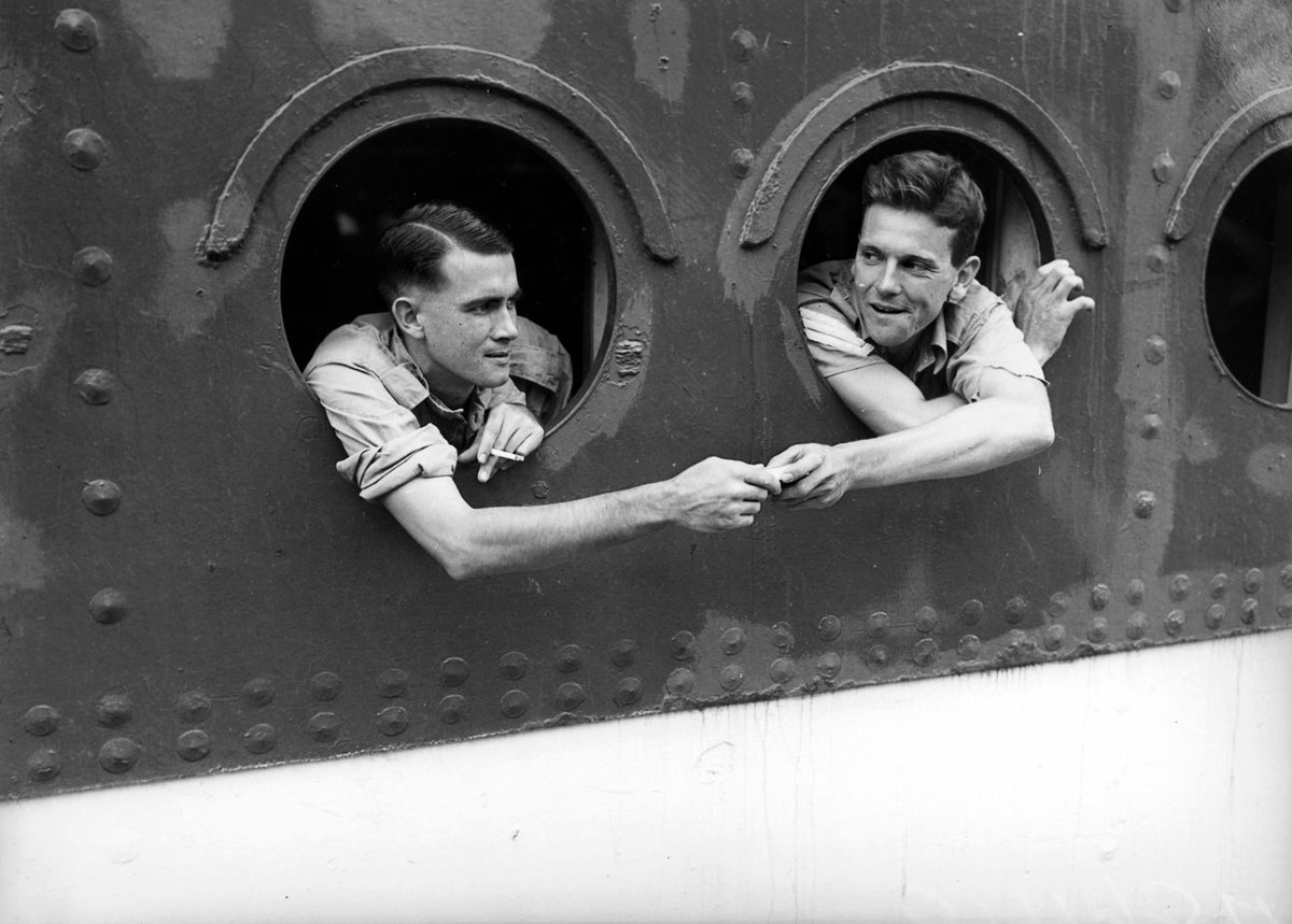 Soldiers looking out the portholes of a ship returning home from overseas, 1942, Brisbane