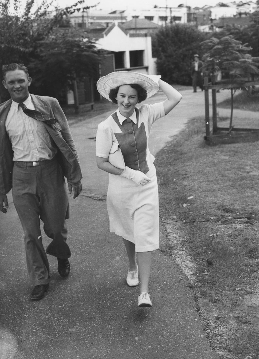 Couple walking along a path near the Brisbane Cricket ground, 1941, Woolloongabba