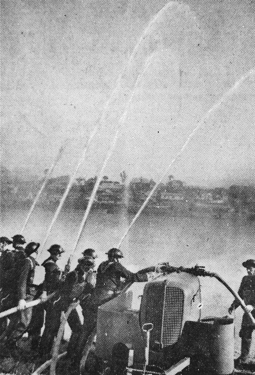Volunteer firemen throwing up a barrage of water from their hoses during their display at the Domain, Brisbane, 1942, Brisbane City