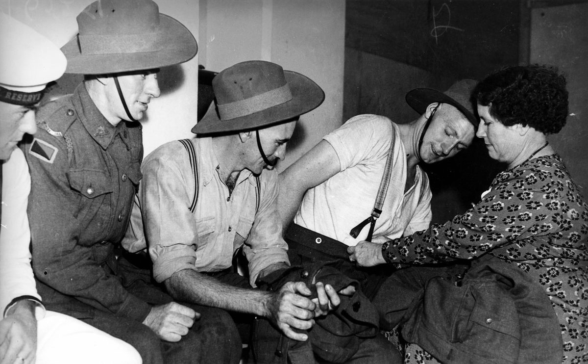 Soldiers and sailors line up for minor clothing repairs, Brisbane, 1940