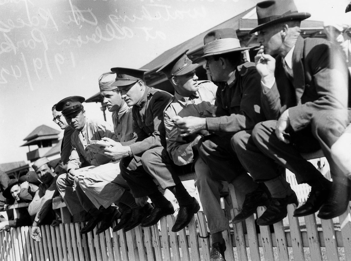 Soldiers sitting on the fence watching the races at Albion Park, Brisbane, September 1942