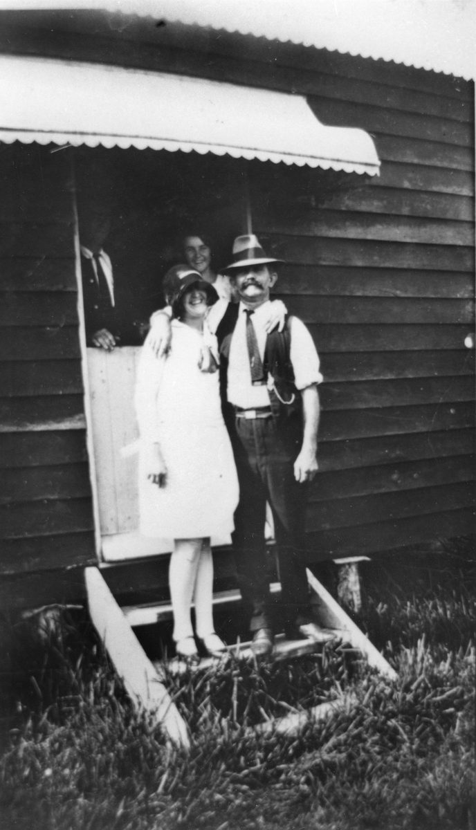 Man and woman standing on the steps of a holiday home at Cribb Island, 1928