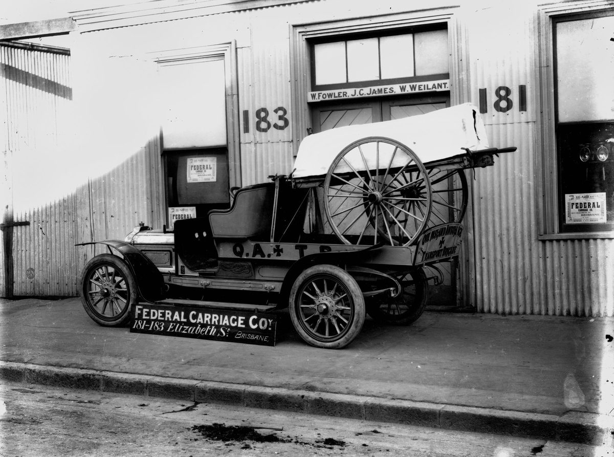 Early motor ambulance and wheeled stretcher in front of the Federal Carriage Co. premises, Brisbane, 1912, Brisbane City