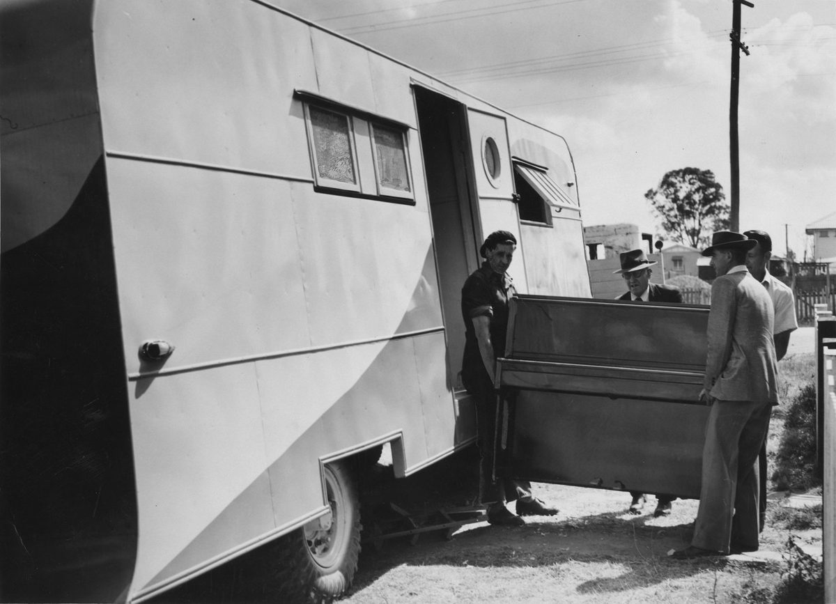 Novel way of moving a piano, using a caravan as a trailer, Brisbane, 1951