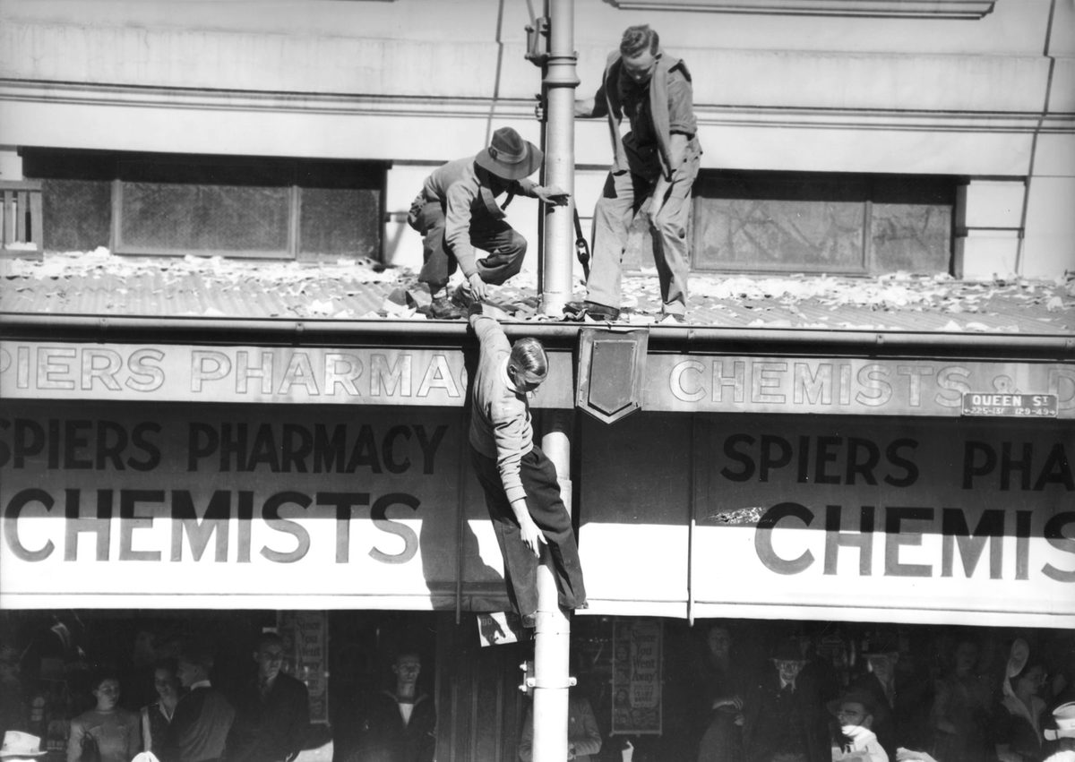 Young men attempt to reach a higher vantage point on VJ Day, Brisbane, 1945